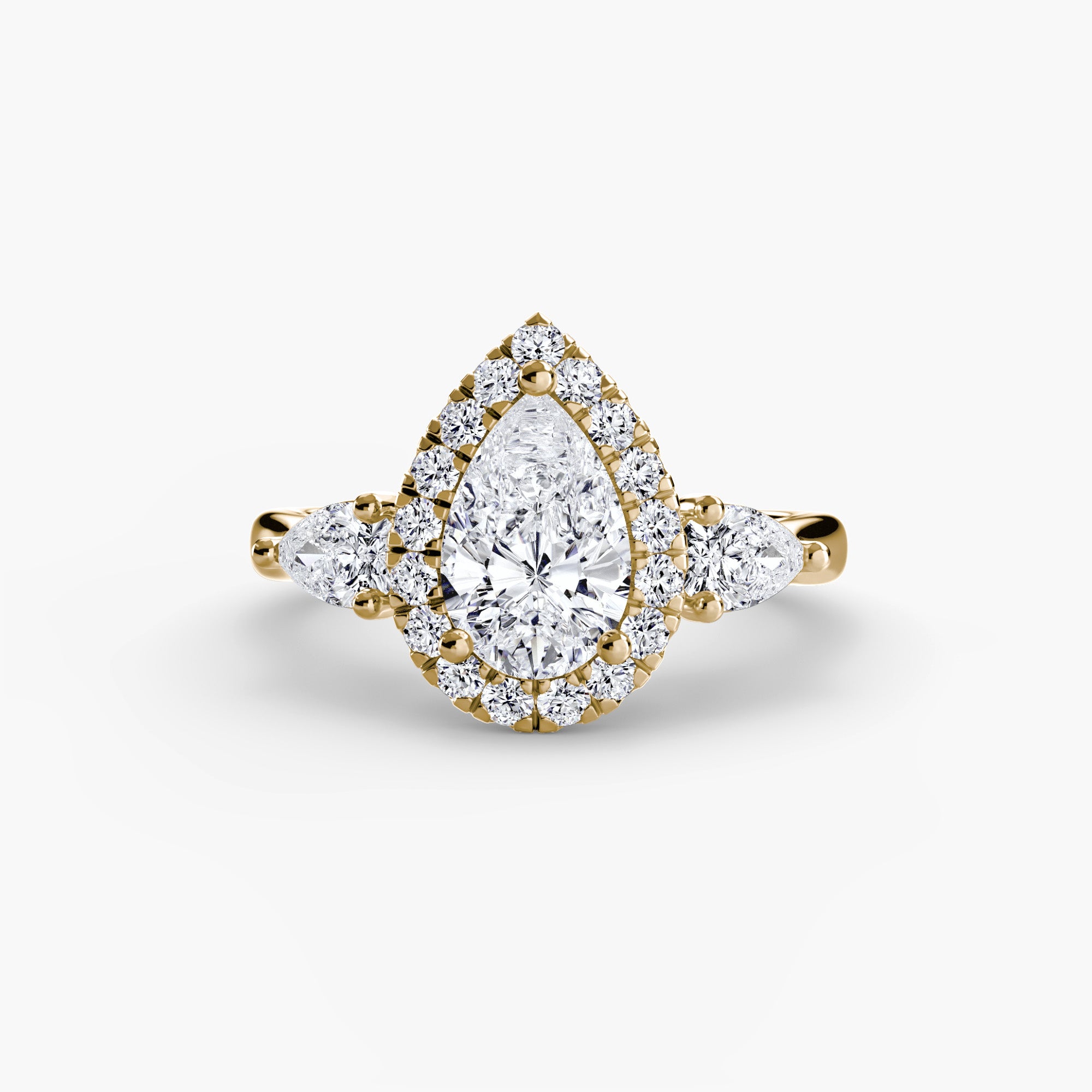 bague Calypso en or jaune, est sertie d'un diamant de laboratoire poire dans un halo et épaulé de deux autres diamants de laboratoire taille poire. Maison française Exquisite Lab Diamonds.