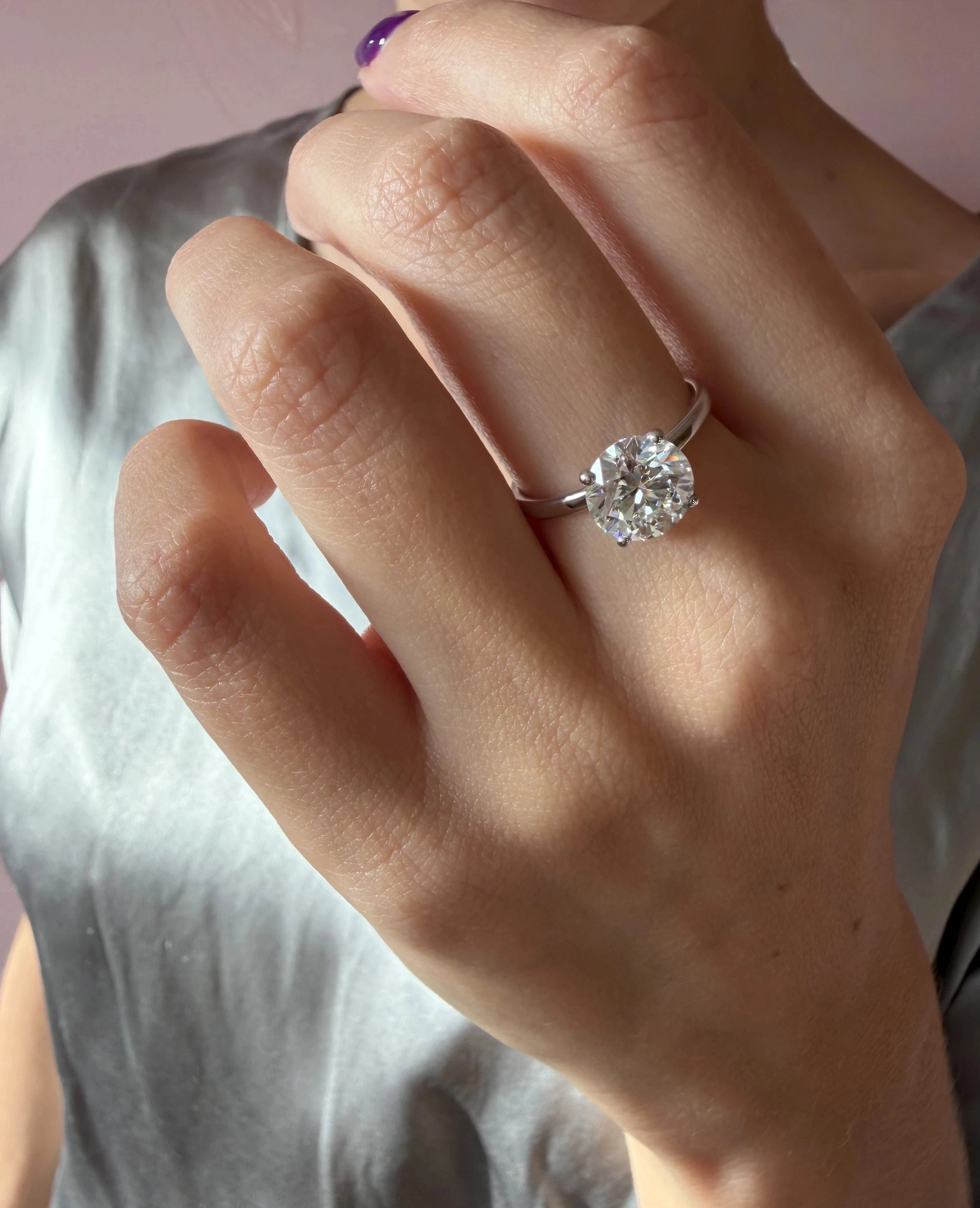 Main portant une bague solitaire en platine sertie d’un diamant de laboratoire rond – Exquisite Lab Diamonds Paris